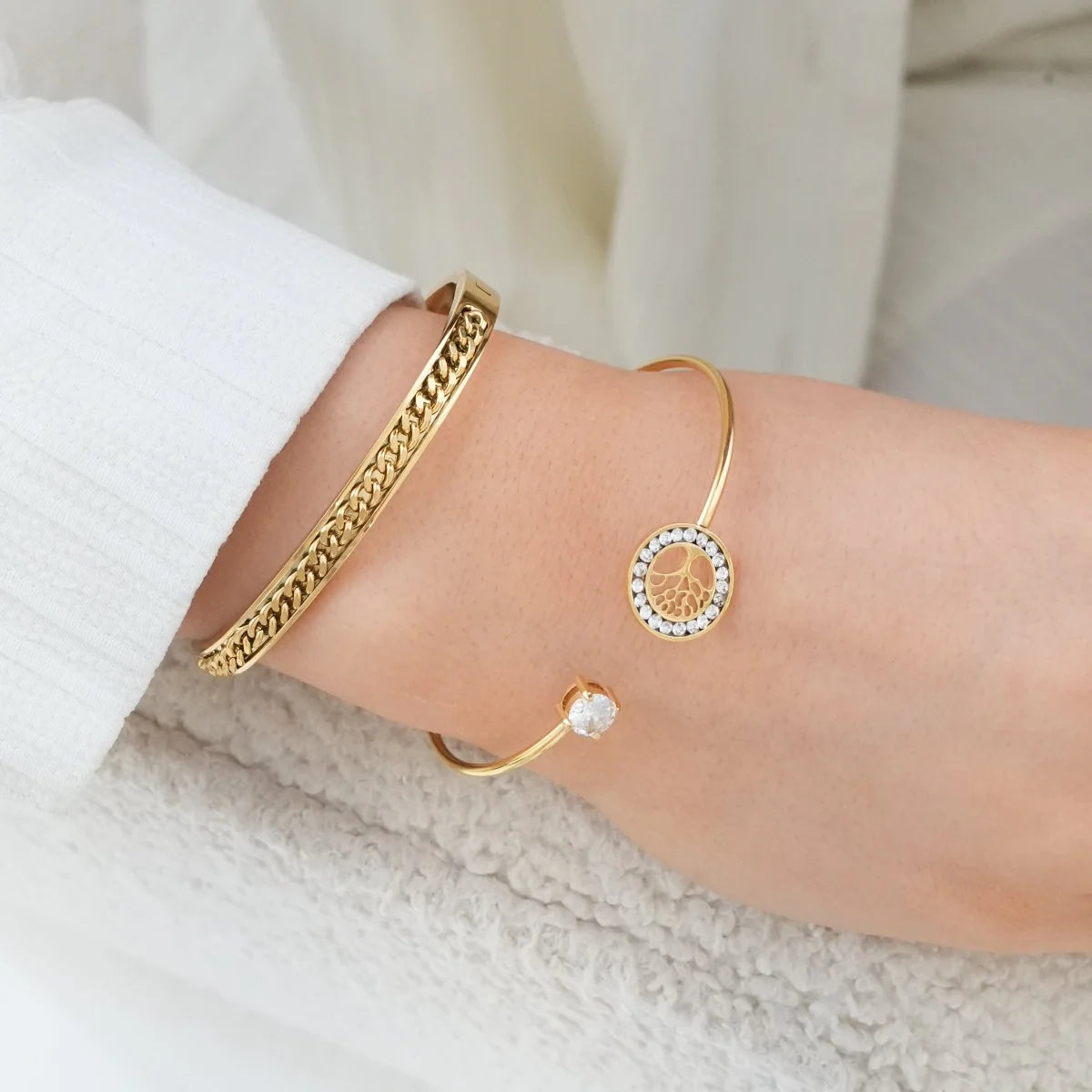 Gold-tone Tree of Life Bangle with symbolic pendant and crystal accent, styled with textured bracelet for a layered jewelry look.