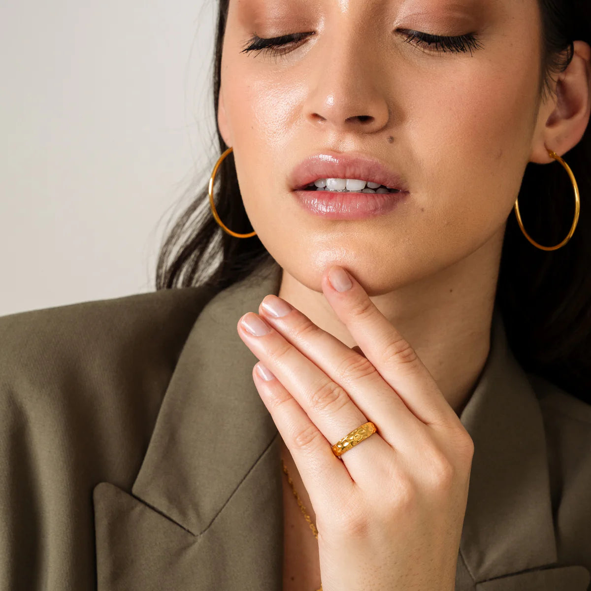 Model wearing Classic Hoops in gold tone with matching gold ring, illustrating a coordinated, timeless jewelry look in the earrings category.